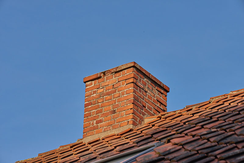 red brick chimney with a blue sky
