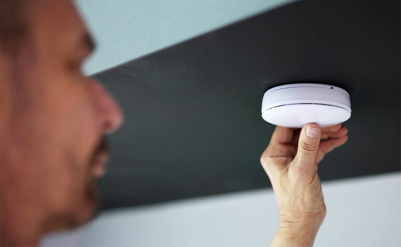 Man inspecting carbon monoxide detector